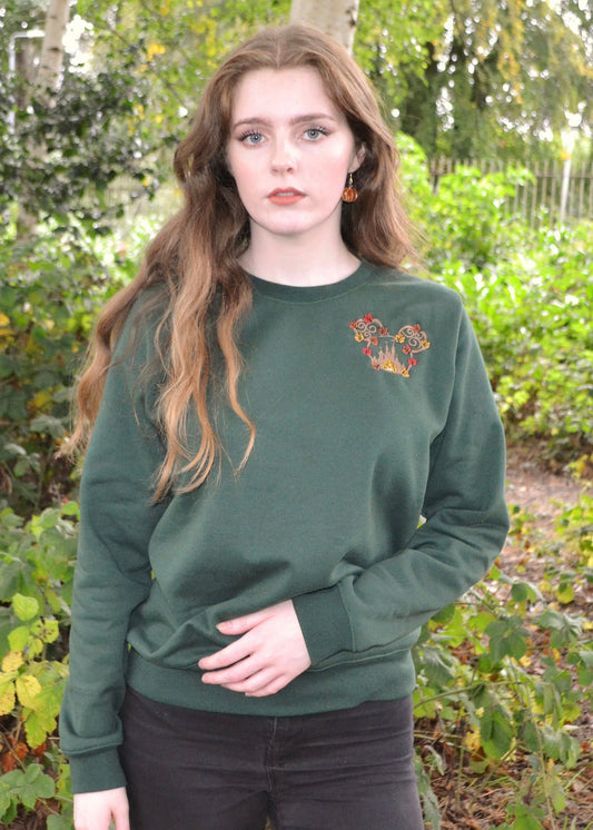 Woman in forest green crewneck sweatshirt with autumn leaf-pumpkin embroidery, woodland backdrop, cosy UK fall fashion