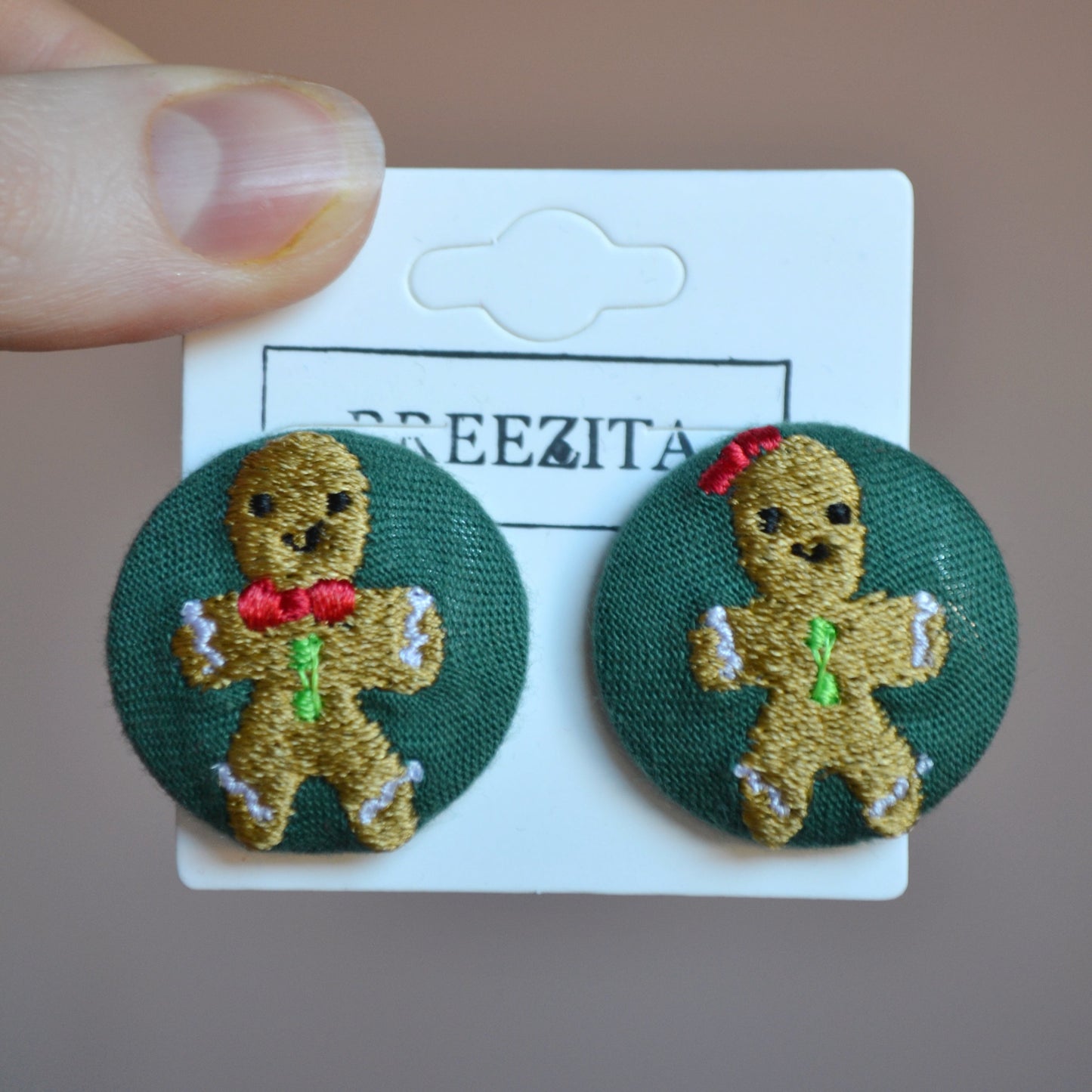 Gingerbread man earrings on a card with 'BREEZITA' branding.